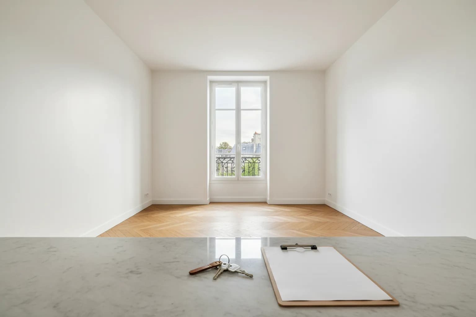 Logement vide et propre, clés et document de constat posés sur un plan de travail